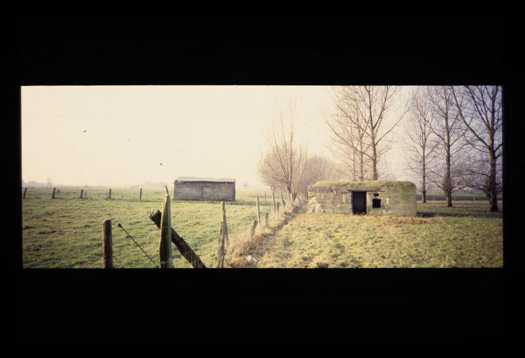 A photo of two bunkers from WWI in a field in Belgium